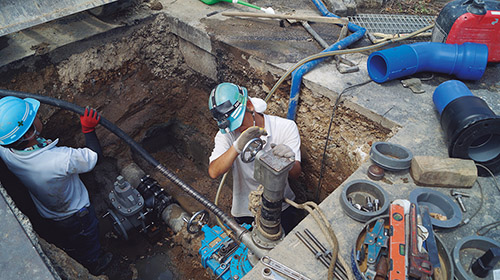 「水道管を工事している人」